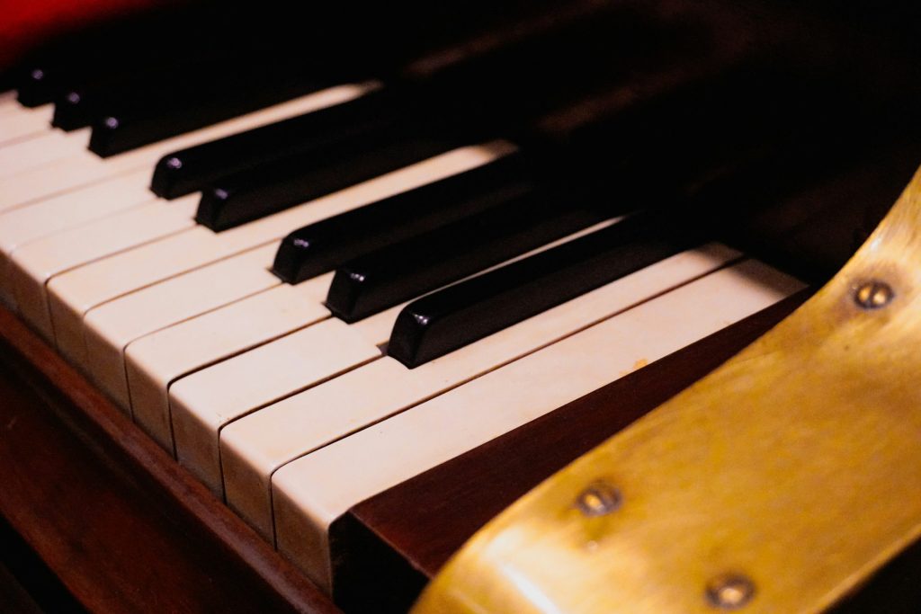 Close-up of piano keys and brass accent